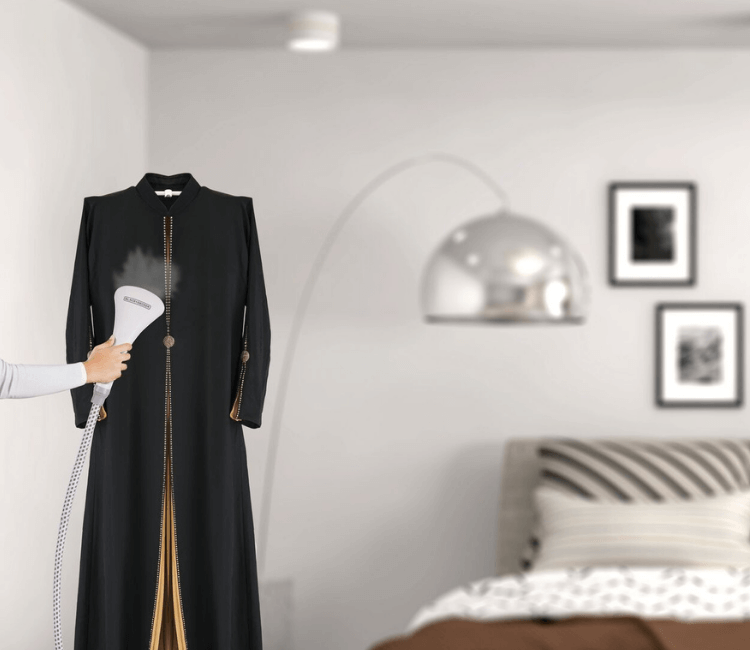 A person quickly steaming a formal garment using the Black+Decker GSTM2050-B vertical steamer, demonstrating fast crease removal and ease of use.