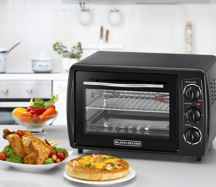 Whole chicken roasting on the spit inside the Black+Decker TRO19RDG-B5 Toaster Oven, showcasing the Rotisserie feature for even cooking.