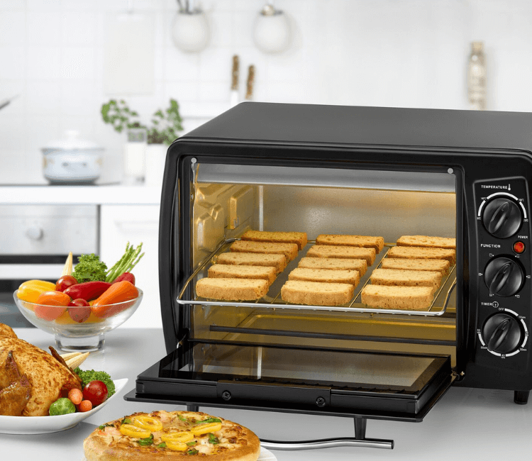 Freshly baked pastries or grilled fish being removed from the Black+Decker TRO19RDG-B5, showcasing the spacious interior and cooking results.