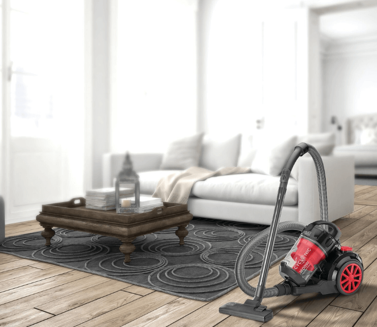 A person easily pushing the Black+Decker VM1680-B5 bagless vacuum across a tiled or wooden floor, demonstrating its lightweight design and maneuverability.