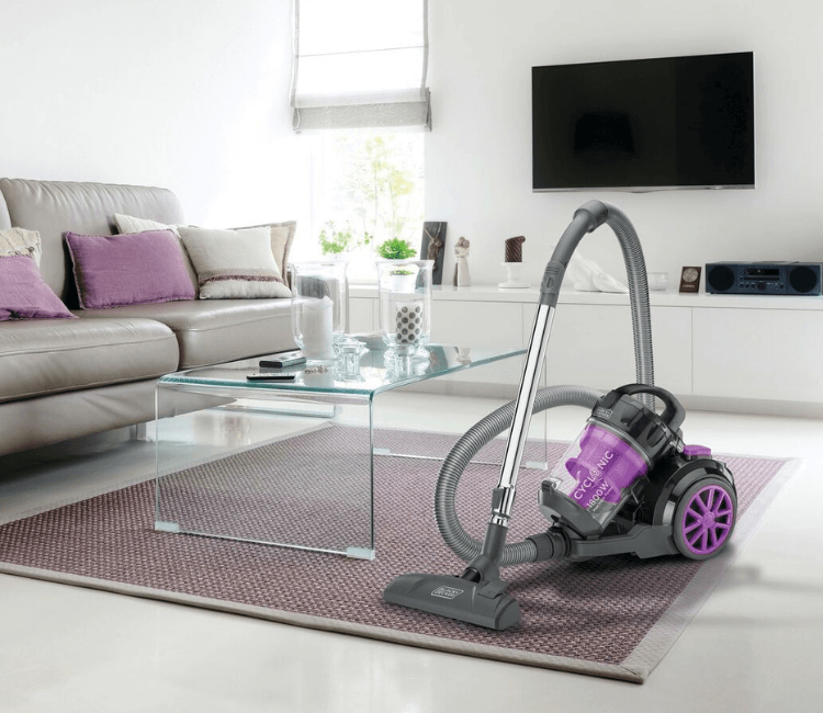 A person using the Black+Decker VM1880-B5 vacuum on a tiled hard floor, demonstrating its smooth maneuverability and effectiveness on multi-surface homes.