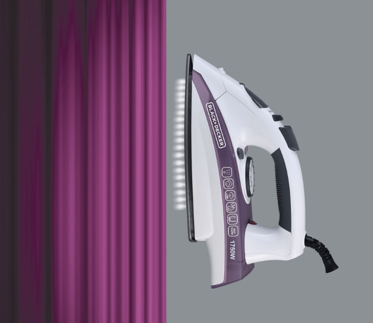 Person using the Black+Decker X1750-B5 steam iron to quickly remove deep wrinkles from a linen shirt, demonstrating powerful steam performance.